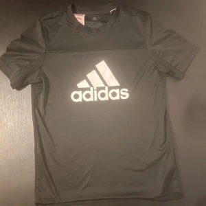 Svart Adidas tränings t-shirt  - Svart t-shirt från Adidas med stor vit logga på bröstet. 