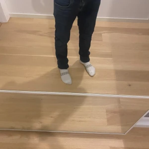 Mörkblå Replay jeans slim fit - Säljer ett par mörkblå jeans från Replay med klassisk femficksdesign och snygga detaljer vid fickorna. Jeansen har en slim passform och är tillverkade i stretchigt denimtyg för extra komfort. Perfekta för dig som gillar en stilren och modern look.