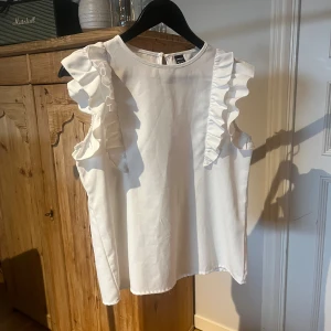 Vit blus med volangdetaljer från Shein - Supersöt vit blus från Shein med volanger längs axlarna. 