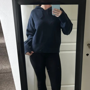 Mörkblå stickad hoodie med huva - Mysig mörkblå stickad hoodie med huva och snörning. Tröjan har en loose passform och långa ärmar, perfekt för kyliga dagar. Enkel och stilren design som funkar till allt. Snygg att matcha med jeans eller leggings.🩷Strl: 170, passar S-M🩷