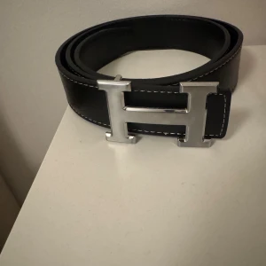 Svart bälte med ett silvrigt spänne  - Nytt svart bälte inte använt en ända gång storlek 115.