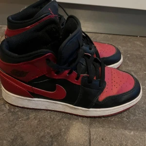 Nike Air Jordan 1 Mid svart/röd strl 38 - Säljer ett par Nike Air Jordan 1 Mid i klassisk svart och röd färg. Ny pris runt 1500. De är använda fåtal gånger
