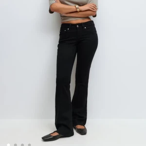 Svarta bootcut jeansbyxor -  Svarta jeansbyxor med bootcut-snitt och låg midja. Klassisk femficksmodell med knapp- och dragkedjestängning samt fickor med lock bak. Snygg passform som ger en tidlös look.  Jeansen är helt oanvända med prislappen kvar!  Original pris: 499kr