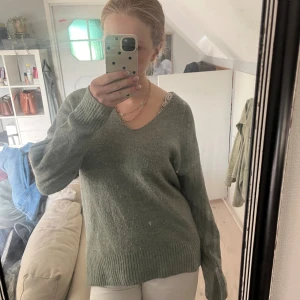 Grön stickad v-ringad tröja - Mysig grön stickad tröja med v-ringning och långa ärmar. Tröjan har breda ribbade muddar vid ärmslut och nederkant, vilket ger en chill och avslappnad vibe. Perfekt för lager-på-lager och passar dig som gillar enkel stil med lite extra comfy känsla. Nypris 300 kr, säljer för 100! Storlek xs men sitter som en s💞