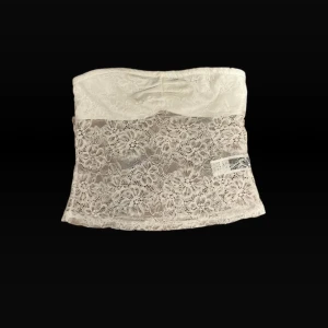 Vit spets tubtopp, storlek xs, aldrig använd! - Säljer en söt vit tubtopp  med blommig spets över hela toppen. Toppen är axelbandslös och har en bandeau-formad överdel. Aldig använd. Storlek xs. Skickar inom 1-2 dagar. Tar emot bud