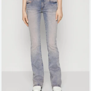 Diesel jeans - Snygga ljusblå jeans från Diesel med klassisk femficksdesign och bootcut-ben. Jeansen har en cool tvättad look, detaljerade sömmar och logotyp på myntfickan. 