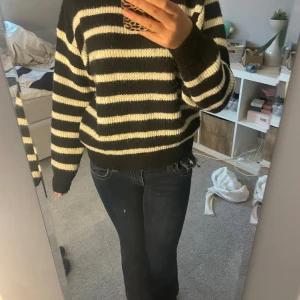 Svartvit randig stickad tröja - Mysig stickad tröja med breda svarta och vita ränder. Tröjan har en klassisk rund halsringning och långa ärmar. Perfekt för dig som gillar en enkel men ändå trendig look. Passformen är normal och materialet känns mjukt och skönt mot huden.