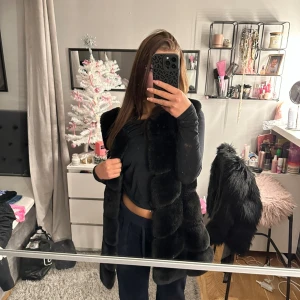Pälsväst lång - Västen är nästan oanvänd då jag haft den i flera år men den ej kommit till användning. Lång och mysig, köpt på miinto.