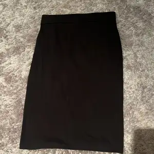 En knälång svart kjol grån lager 157. Varan är avstängd ett par gånger men inga slitage syns.