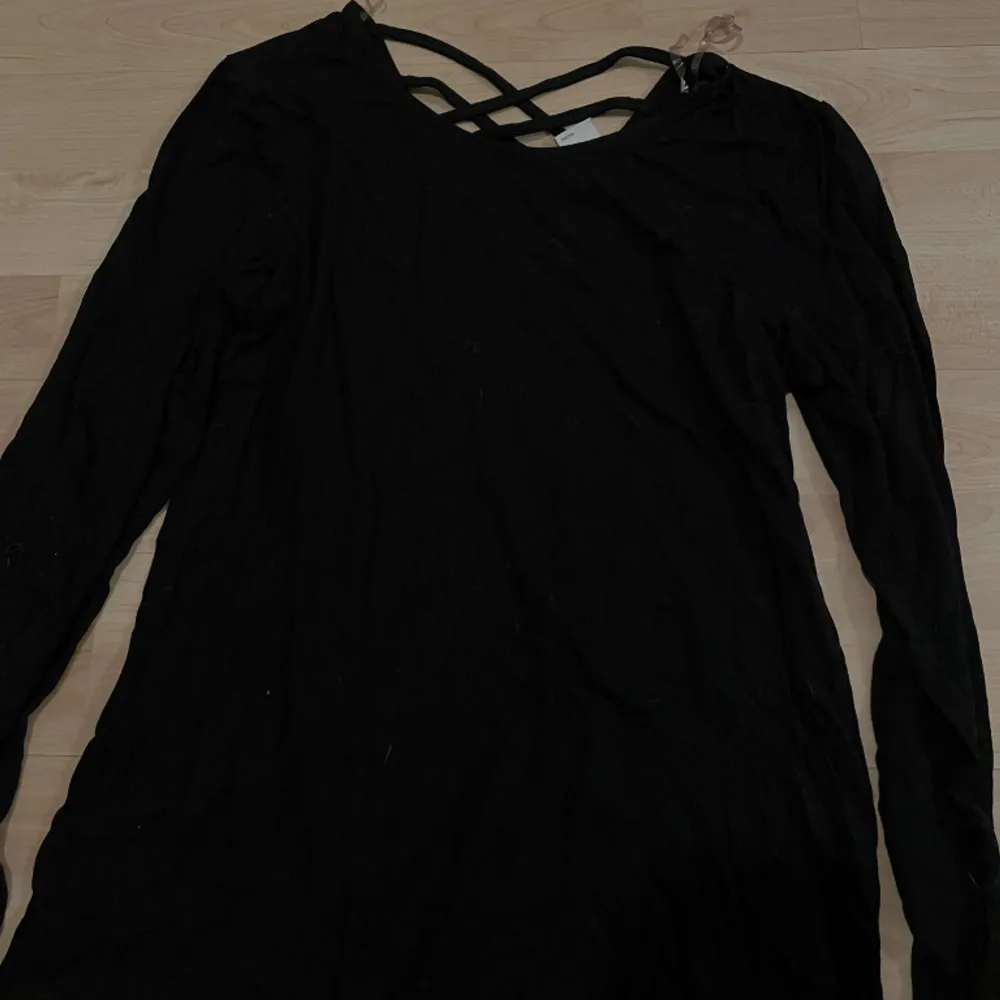 En svart tröja som har uppen nacke back med snören . Tröjor & Koftor.