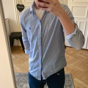 Ralph lauren skjorta  - Säljer denna randiga skjortan skjortan till ett blligt pros, perfekt till sommaren🥂 Den är näst intill oanvänd skick 9/10. Hör av dig vid minsta bekymmer🙏🏻