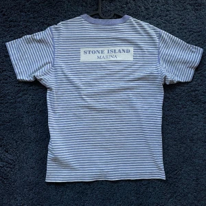 Stone Island T-shirt Blå Strlk Small  - Fräsch blå stone island tröja med logga på bröstet och text på ryggen. Sitter som storlek small. Notera att det finns några små pinholes, se sista bilden. R 3 P från topstoney