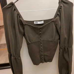 korsettopp med puffärmar - korsettliknande topp med puffärmar från zara! något croppad i modellen. nyskick! kan finnas någon lös tråd. 