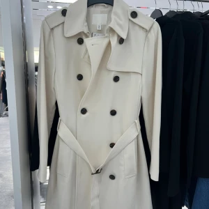 Vit trenchcoat - Säljer min fina vårkappa i superfin färg, storlek 38. Perfekt nu till våren 💜