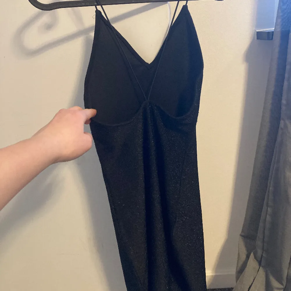 En glittrig svart klänning från H&M. Jätte fin och perfekt som festklänning. Använt vid några tillfällen, säljer för den är för liten. Den är i bra skicka och väldigt bekväm! . Klänningar.