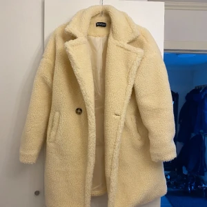 Teddy kappa  - Teddy kappa i cream färg. Aldrig använd! Längd till knäna. 