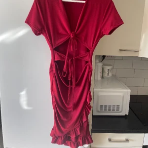 Röd klänning  - Nyskick, stretchig klänning man knyter där fram. Kolla alla bilder för att se hela klänningen ❣️
