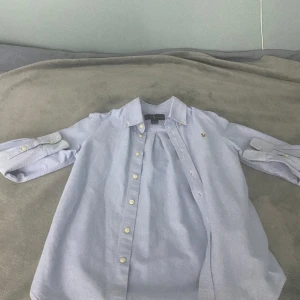 Ralph lauren skjorta  - Jag säljer min Ralf lauren skjorta för den har blivit för liten. Det är bara att skriva om ni vill ha mer bilder. Skick 9/10 knappt andvänd.  Storlek 134/140 10y