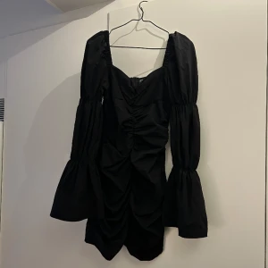 Svart klänning  - Svart klänning med puffärmar som endast är använd en gång!