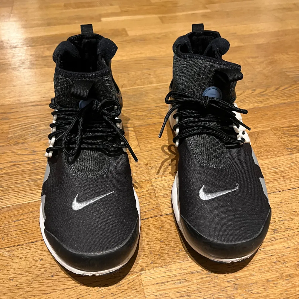 Nike air presto mod utility. Svarta med gråa blå och vita detaljer. Använda sparsamt . Skor.