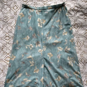 Blå långkjol - En fin blå långkjol med mönster och fickor. Perfekt nu inför våren och sommaren!🌱🌸 Midjemått: 38cm (tvärs över) Längd: 72cm