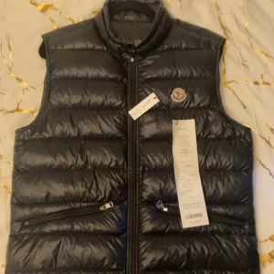 Moncler Gui Väst -  Moncler Gui väst som också är i ny skick (aldrig använts i regn elle snö) Skick 9,5/10 Size - 4 Kvitto ingår mötas up i Göteborg trakterna eller frakta på önskan Äkta såklart!!