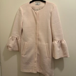 Ljusrosa kappa - Ljusrosa kappa i storlek small.