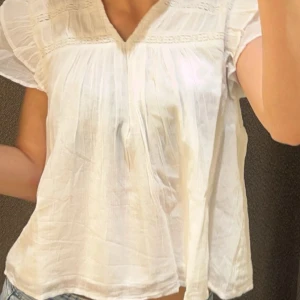 neo noir liknande blis ifrån gina  - en jättefin vit blus ifrån gina med volanger och en liten v-rigning 