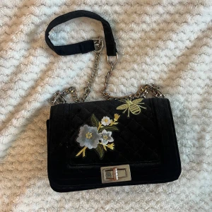 Väska med kedja - Superfin väska med silverkedja och gulliga detaljer (bin och blommor tihi). Lite missfärgning vid "spännet" men annars i väldigt bra skick!