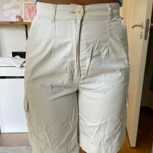 Vita shorts med hög midja - Vita shorts med hög midja. Säljes då de blivit för små. Har ett par fläckar på höger baksida. Modell bär vanligtvis 36/38 och är 165cm