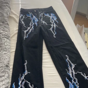 Jeans  - Svarta jeans med blixtar  Storlek S  Pris 40 kr