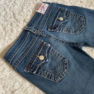 Vintage True Religion jeans - True Religion jeans i modellen ”Joey”, bootcut och lågmidjat. 😍 Perfekt skick utan några defekter! Innerbenslängd och midjemått på bifogade bilder, men kan fixa fler mått vid behov. Jag är 167. ❤️ Håll koll på min profil, har flera vintage jeans uppe!