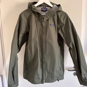 Patagonia regnjacka  - Grön regnjacka som är vattenavvisande och vindtålig. 