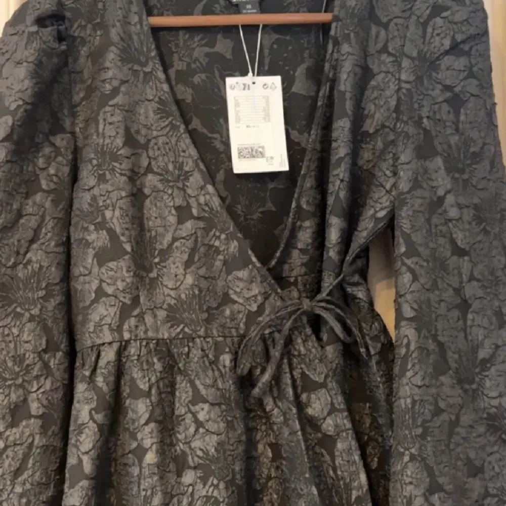En svart puffig klänning från Monki som är helt ny & aldrig använd, med prislappen kvar, nypris: 500 kr. Storlek Xs. Har ett blommigt mönster som man ser på bilderna. . Klänningar.