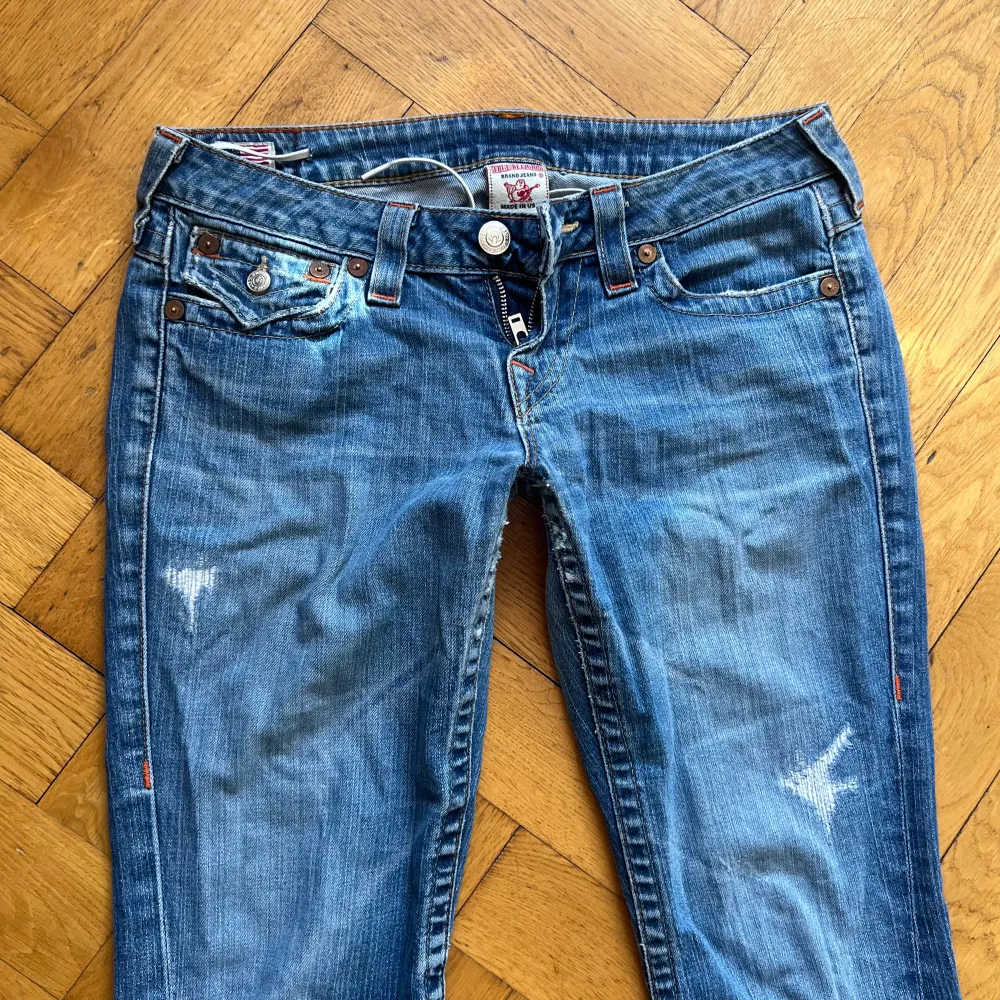 Lågmidjade True Religion jeans i modellen bootcut. Har defekter (se sista sliden), hål under rumpan som blivit ihoplappade (fortfarande små hål), två hål vid fickorna och slitage längst ner. Mått i cm: midja: 42, Innerben: 79. Jag är 165 ❤️. Jeans & Byxor.