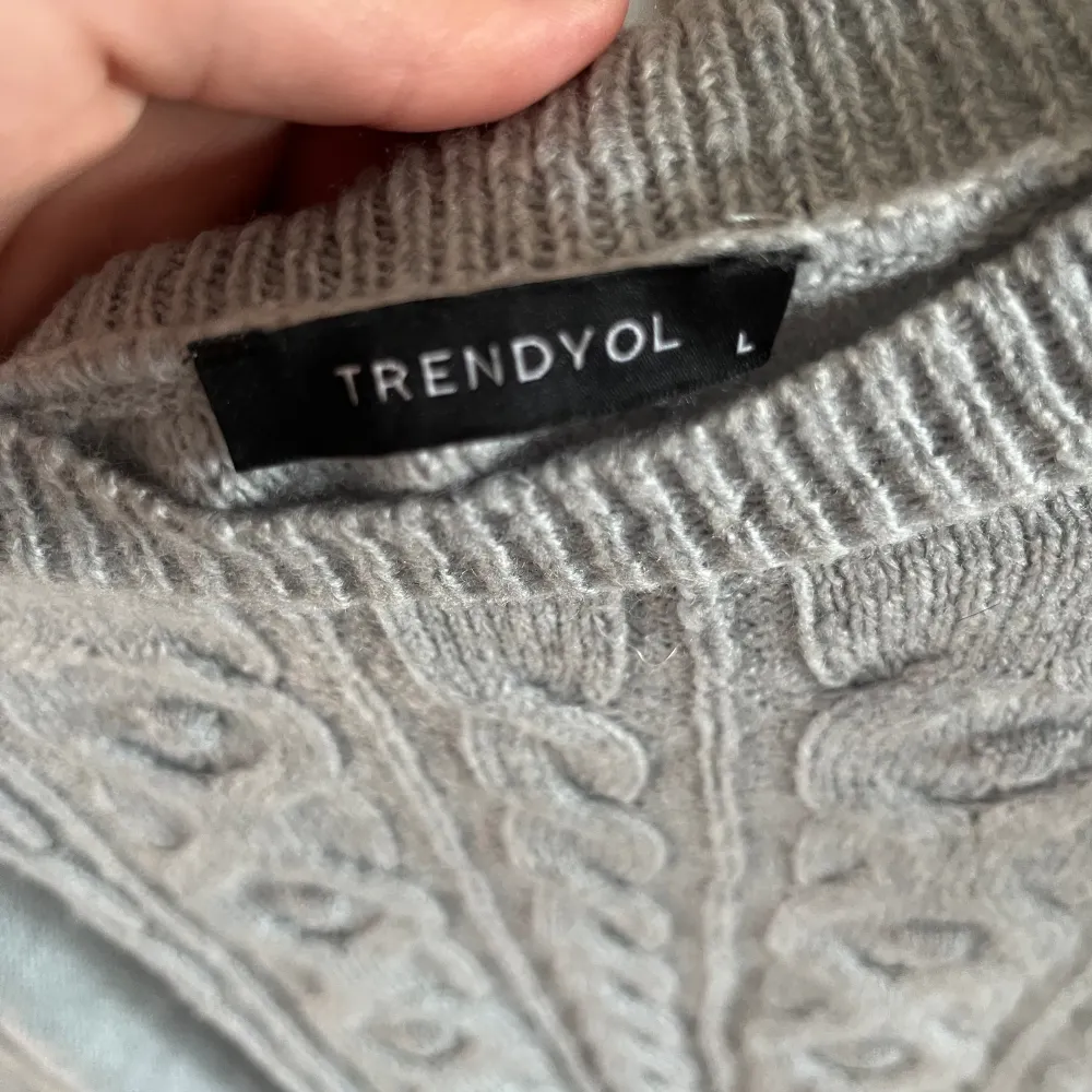 Säljer denna grå mönstrade stickade tröjan i storlek L . Stickat.