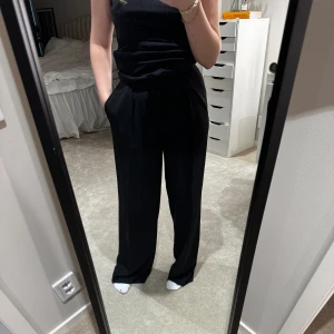 kostymbyxor - Svarta lösa kostymbyxor från HM i bra skick! fickor både fram och bak