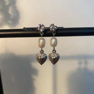 Pearly heart - Söta små ”sötvattenspärlor” s örhängen med ett hängade hjärta och en glittrig stud. Delvis rostfri🩶