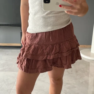 Kjol med volanger  - Säljer denna röda kjol, finns matchande topp i profilen. Köpt på brownie för 500kr för två år sedan, men använder inge längre.