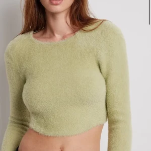 fluffig grön kort tröja - Superfin fluffig grön topp med öppen rygg från nakd, från en kollektion som ida carlsson gjort💕slutsåld i denna storleken på hemsidan just nu. säljer då den tyvärr blivit för liten för mig 🥰