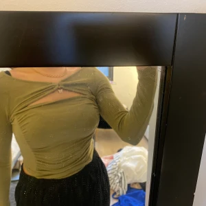 Grön topp med fjäril - Olivfärgad grön topp med fjärilsdetalj