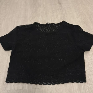 Svart spets topp från Bik Bok - En spets topp från bik bok i strl S.                         En super fin tröja som tyvärr inte kommer till användning längre.Den är ganska genomskinlig som man ser på sista bilden men funkar bra med bh eller linne under beror på vad man är bekväm med