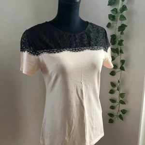 Supersnygg topp med spets - Jättefin topp iny skick i ljusaprokot/beige färg, med spets.  Obs att provdocka har strl XS-S och topp sitter utmärkt på 👌