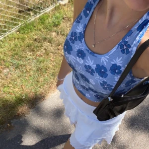 Blå topp - Blå, blommig topp med öppen rygg o lite ribbad i materialet 🩵 Köpt för nåt år sen o knappt använd så i princip som ny. Skriv i chatten för fler bilder eller frågor!  Köparen står för frakten 💗