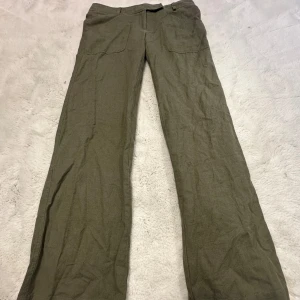 Lågmidjade linnebyxor  - Säljer ett park mörkgröna Lågmidjade linnebyxor från märken Twist & Tango. De är i väldigt bra skick!  Byxorna är i 50% linne💚  På etiketten är storleken M men skulle uppskatta mer till en S     Midjemåttet är 39cm platt och innerbenslängden är 84cm✨