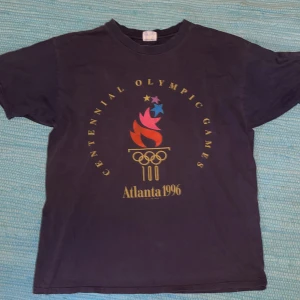 Vintage t-shirt - Gamla goda OS i Atlanta 1996, du borde varit där. Det nästa bästa du kan göra är att investera i en vintage t-shirt producerad av det väletablerade företaget Champion.
