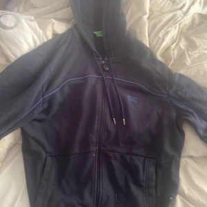 En mörkblå Hugo boss kofta - En mörkblå Hugo boss kofta helt okej skick storlek L kan se solbränd ut men det är den inte utom det är pga ljuset så skick meddelanden för mer bilder och så