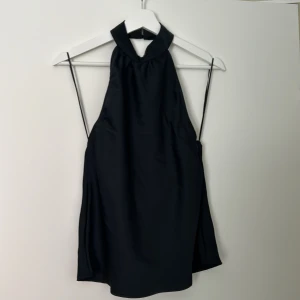 Silkes topp - Super fin svart silkesttopp med halter neck och öppen rygg. Använd 1 gång så jättefint nyskick.  