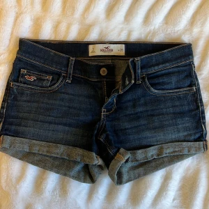 Hollister Low Waist denim shorts - Säljer dessa sjukt snygga lågmidjade denimshorts från Hollister i storlek W26💙 Passar XS/S - Midjemått 37 cm tvärsöver - Längd fram 22 cm - Längd bak 27 cm 
