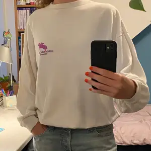 Vit sweatshirt med tryck både fram och bak. Står att storleken är XL men hade sagt att den är M. ☀️ Skriv för fler bilder eller frågor om plagget 😊